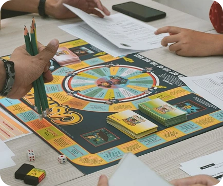 Mensen die een educatief bordspel spelen met kaarten, dobbelstenen en werkbladen, waarbij plezierig spelplezier wordt gecombineerd met leerzame activiteiten